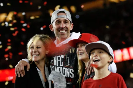 mandy shanahan with her husband and children inside a football stadium