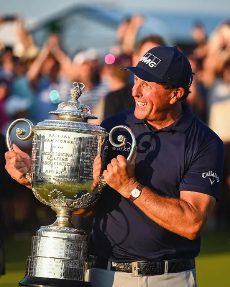 phil mickelson holding the trophy in his hand